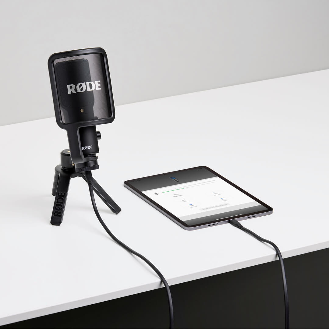 NT-USB+ on white desk connected to mobile phone showing RØDE Reporter