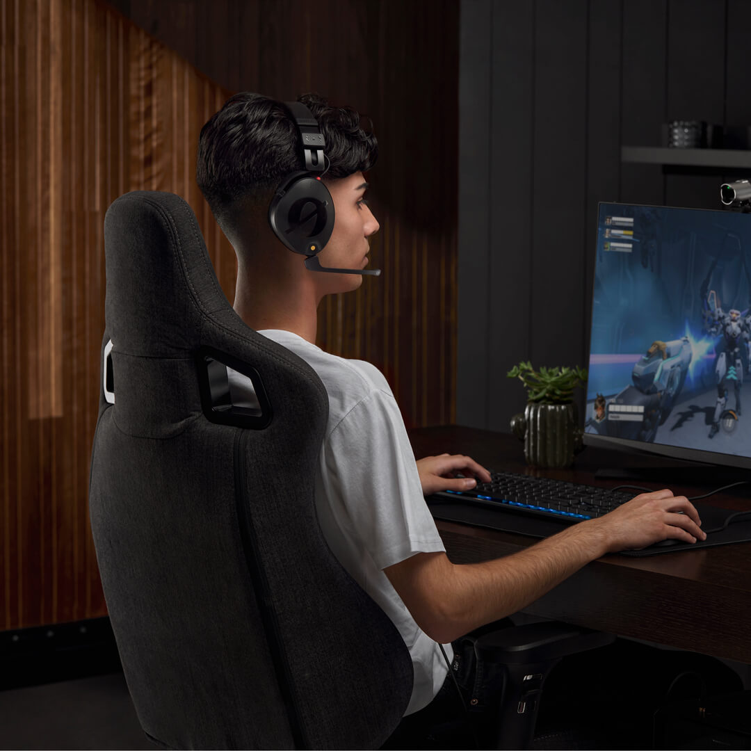 Boy wearing NTH-100M in front of computer screen playing video game