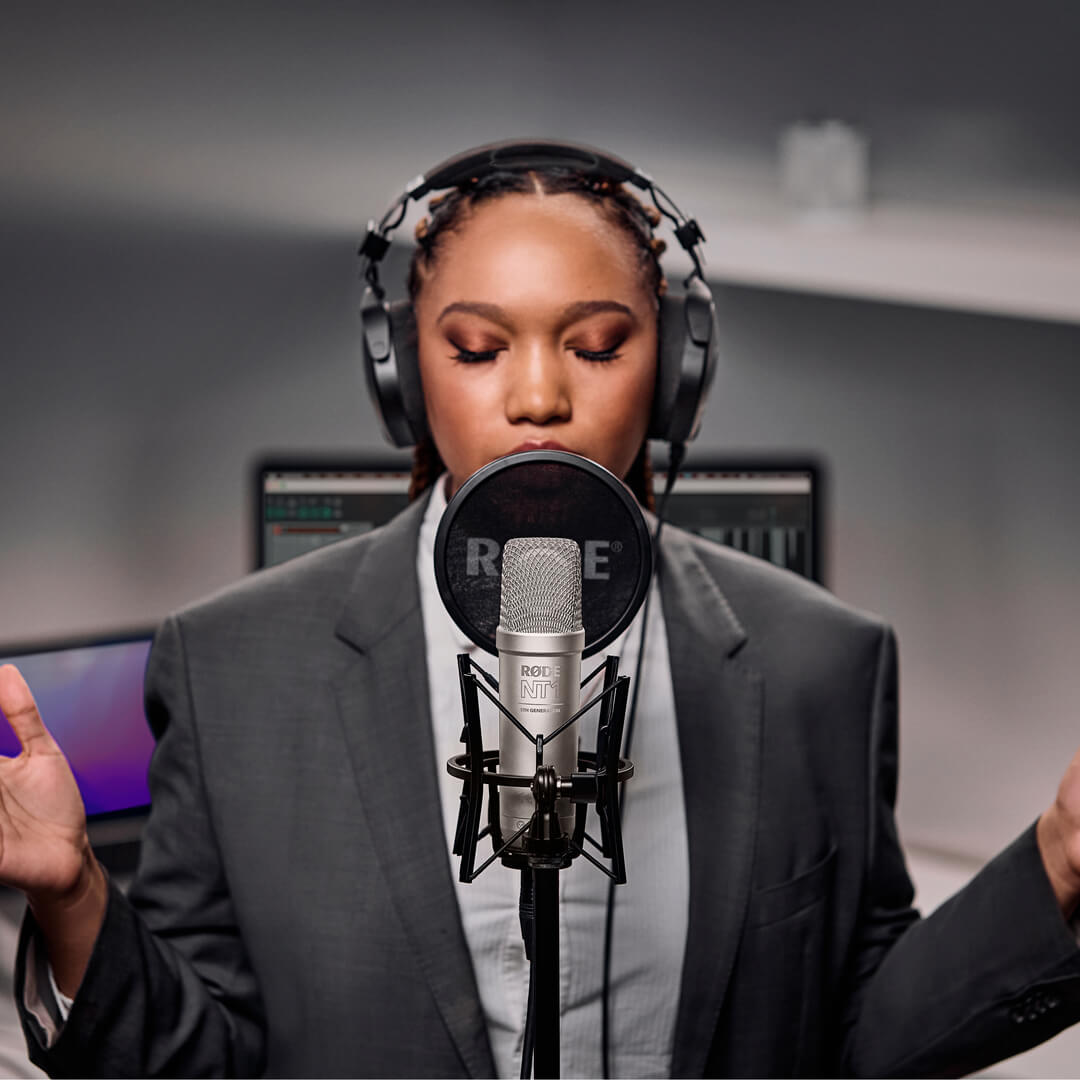 Girl wearing NTH-100M recording with silver NT1 5th Generation in home studio